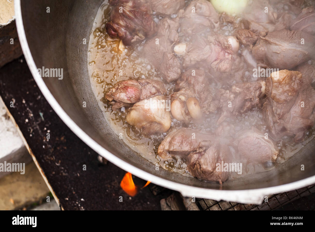 Agnello con cipolla ebollizione in un calderone. Preparazione della zuppa Chorba, pasto tradizionale per molte cucine nazionali in Europa, Nord Africa e Asia Foto Stock