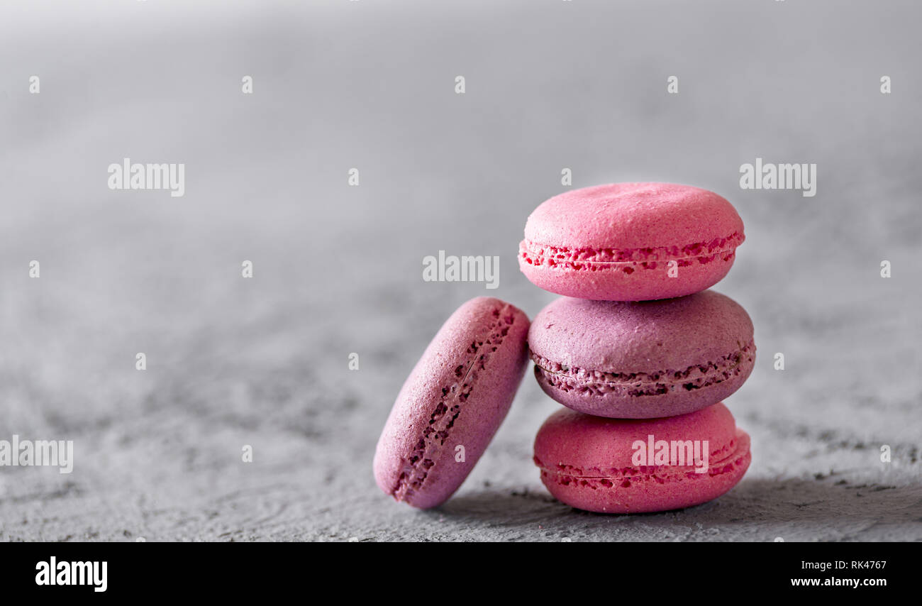 Bella colorata deliziosi dessert makarons, stack sulla pietra grigia sullo sfondo. Foto Stock