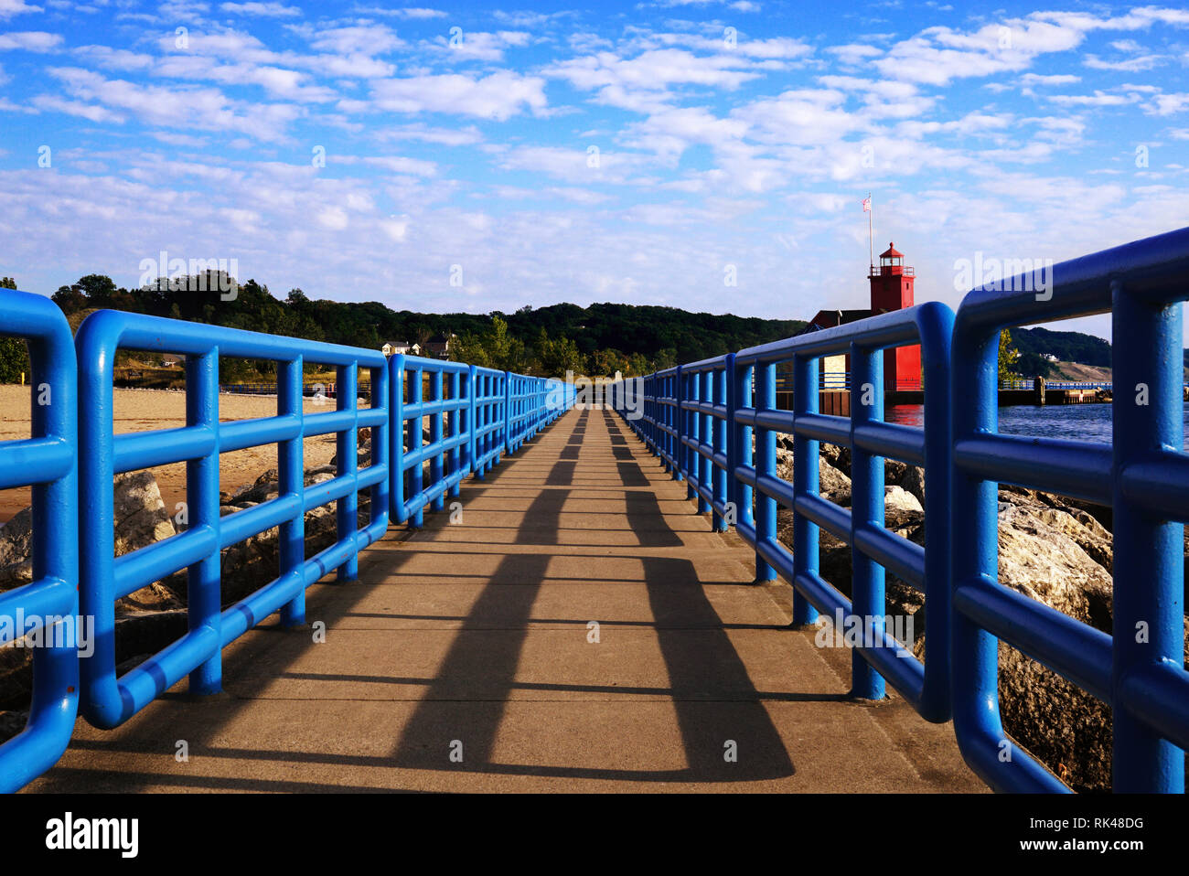 Pontile con blu brillante recinzione in prospettiva. Big Red faro sul Lago Michigan. Holland luce del porto. Blu brillante recinzioni sul molo, dietro th Foto Stock