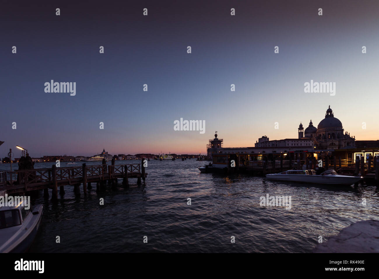 Venezia, Italia - 10 febbraio 2018: vaporetto il terminale al tramonto davanti alla Basilica della Salute. Il vaporetto è il mezzo pubblico per eccellenza di Foto Stock