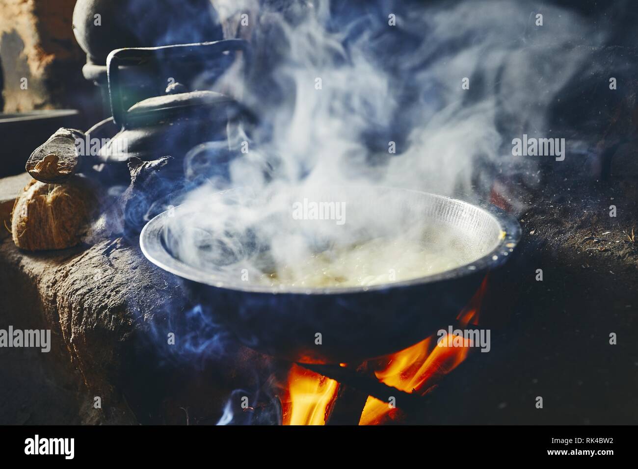 Preparazione di riso e curry pasto. La cottura su una buca per il fuoco nella tradizionale cucina casalinga in Sri Lanka. Foto Stock