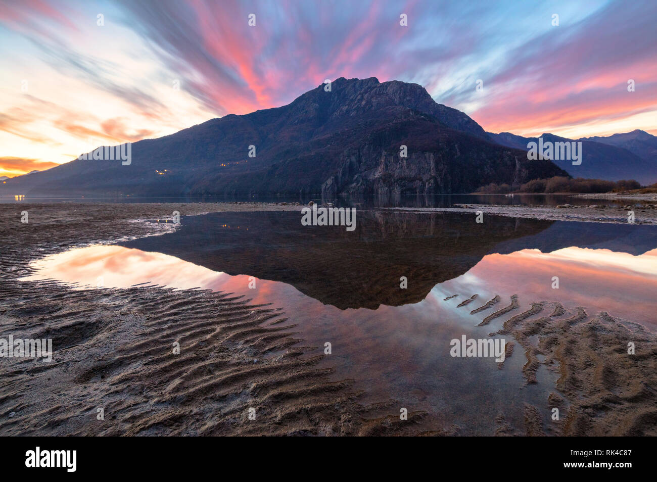 Monte Berlinghera specchiata in acqua al tramonto, Novate Mezzola, Val Chiavenna, provincia di Sondrio e della Valtellina, Lombardia, Italia Foto Stock