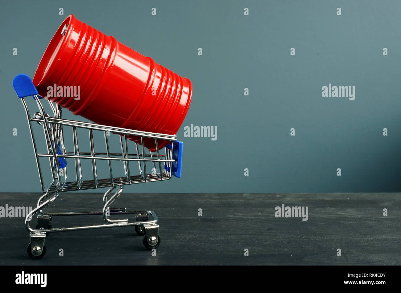 Carrello spesa e la canna del cilindro con olio come simbolo di trading. Foto Stock