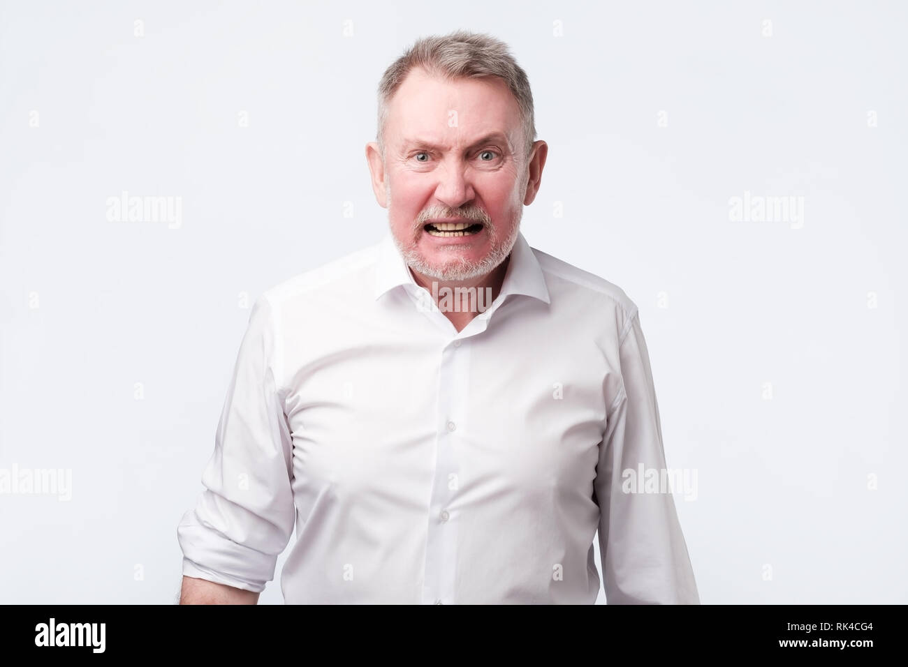 Urlando senior Uomo in camicia bianca. Negativo emozione per il viso Foto Stock