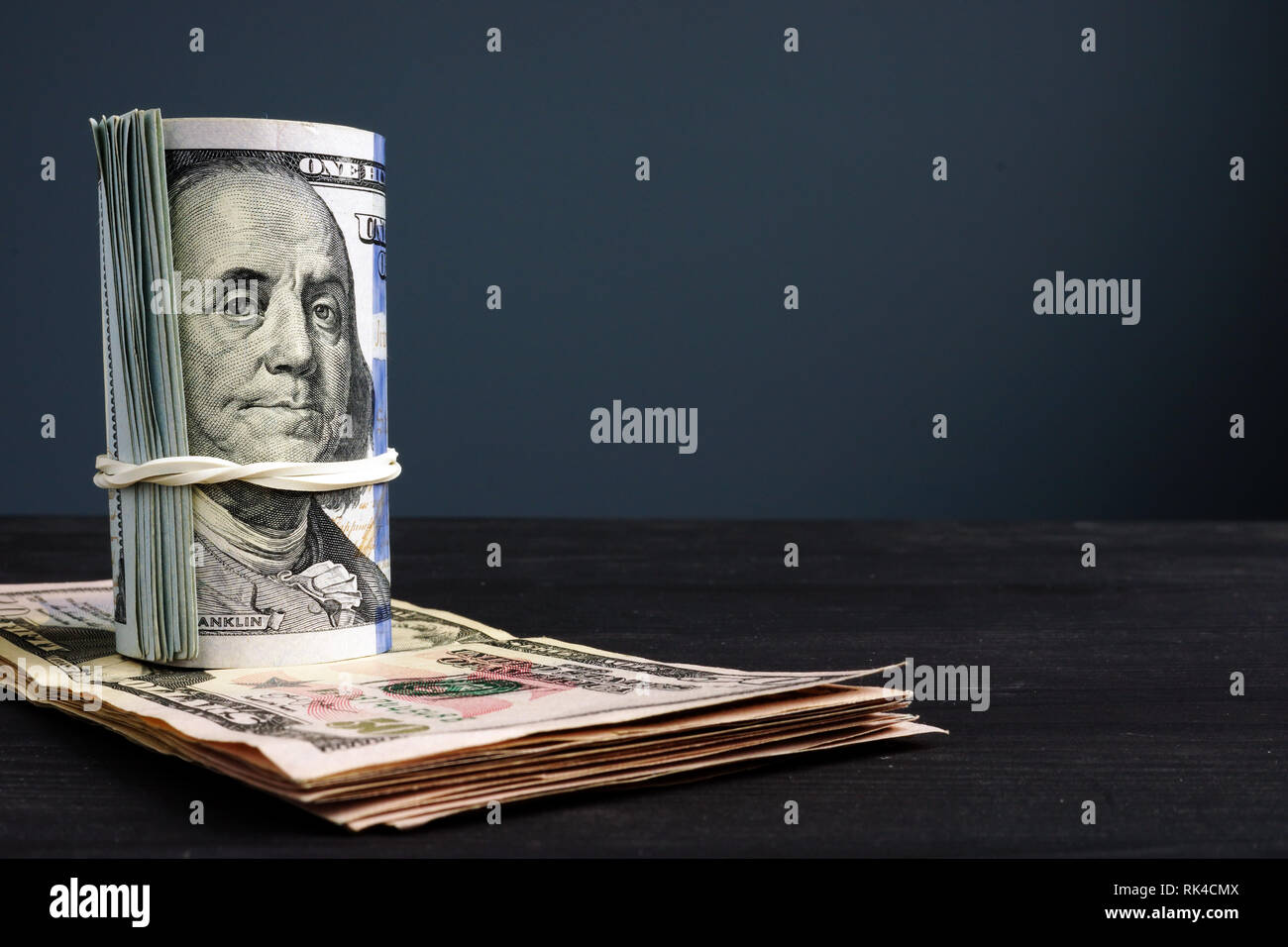 Laminati banconote di dollari su una scrivania con spazio libero. Foto Stock