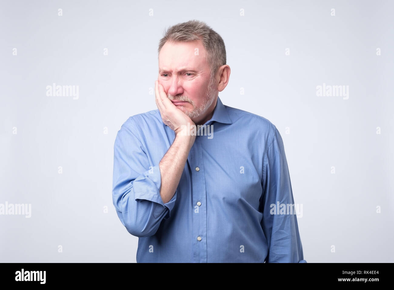 Senior Uomo in camicia blu sofferenza Dente dolore Foto Stock