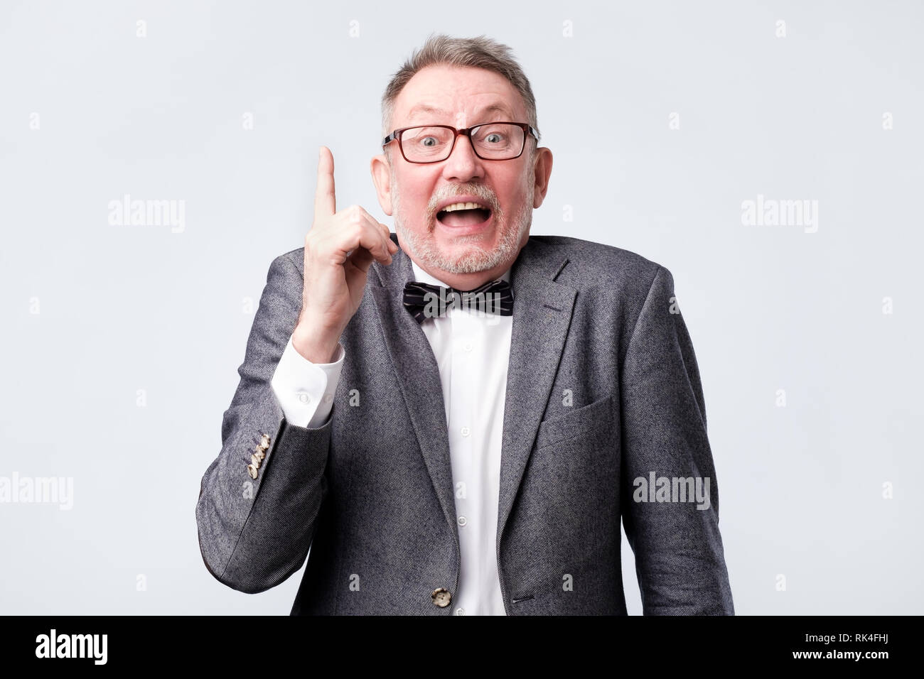 Felice l'uomo senior che mostra le dita indice fino, dando suggerimenti o consigli Foto Stock