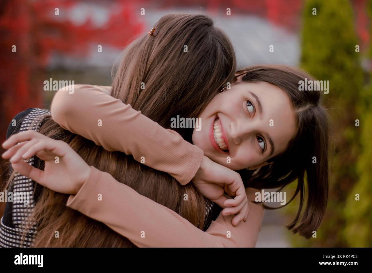 La ragazza abbracci la sua fidanzata saldamente. Felice bella studente è felice di incontrare un amico in autunno park Foto Stock