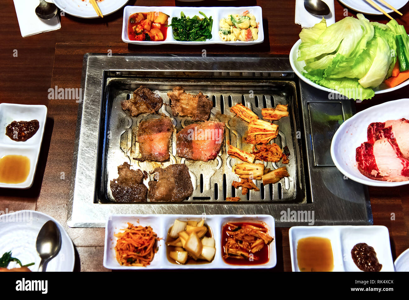 Il coreano tradizionale pasto con barbeque e verdure in un ristorante Foto Stock