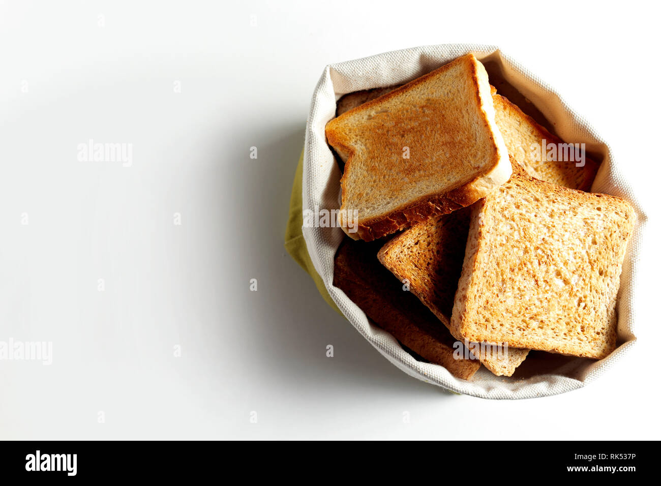 Toast fritti fette di pane mettere in borsa bianca e visto dal di sopra su sfondo bianco con ombra. Spazio di copia Foto Stock
