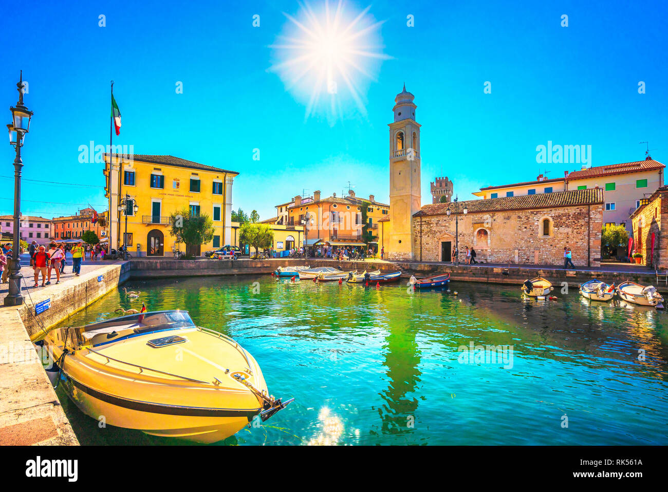 LAZISE, VENETO / Italia - 28 settembre 2018: Barche nella città vecchia porto di Lazise e turisti a piedi al mattino. La città è famosa per le vacanze desti Foto Stock