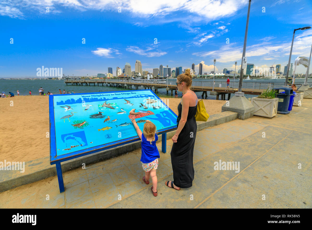 San Diego, California, Stati Uniti - 1 Agosto 2018: la mamma con il bambino cercando segno interpretative del quartiere di San Diego Bay nei pressi di Coronado Ferry Foto Stock