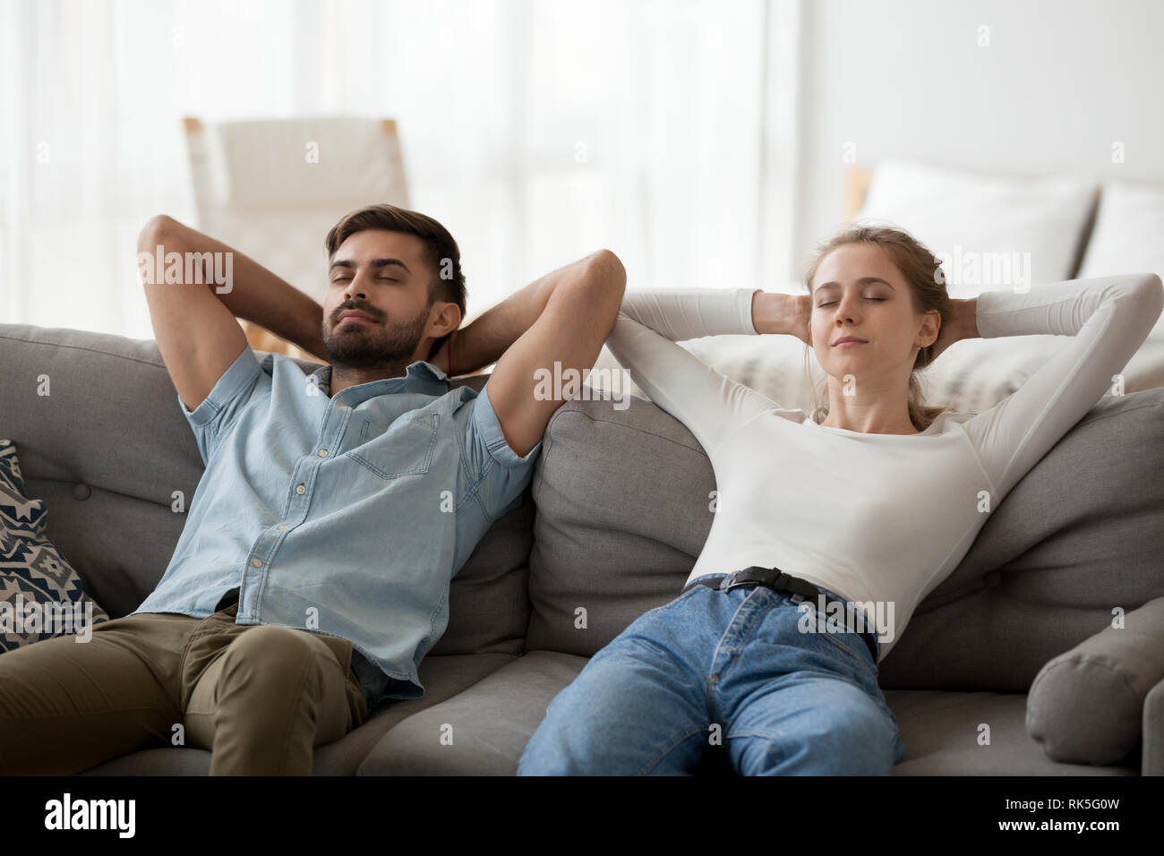 Calma lazy giovane rilassarsi su confortevoli divani in appoggio insieme Foto Stock