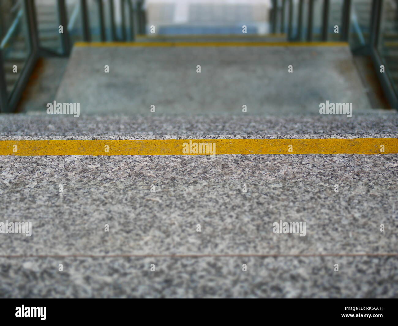 Immagine di scale in granito con linea gialla marcatori goind verso il basso Foto Stock