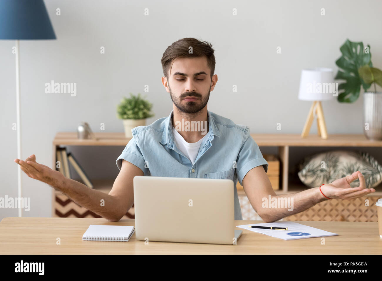 La calma atmosfera tranquilla giovane uomo prendendo pausa di lavoro la pratica dello yoga Foto Stock