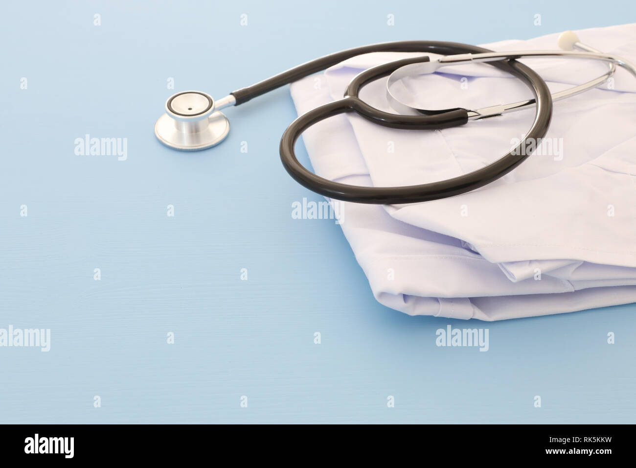 Foto di uno stetoscopio e medico cappotto blu su sfondo di legno. Concetto medico Foto Stock