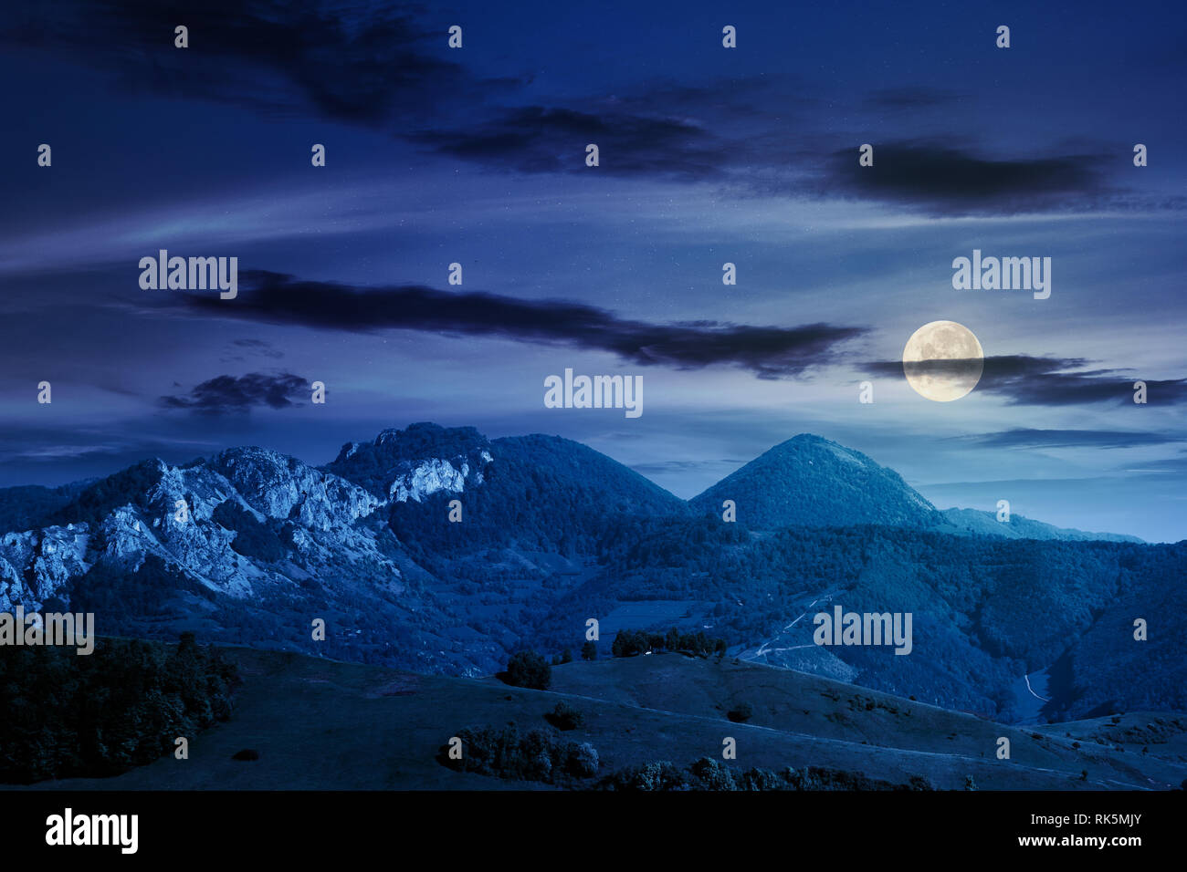 Paesaggio di montagna con formazioni rocciose. prati erbosi, colline coperte di boschi e di enormi scogliere. bellissimo paesaggio naturale. tempo bello di notte in Foto Stock