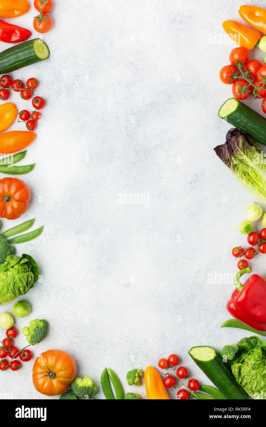 Fresco cibo crudo Pomodori Cetrioli lattuga pepe cipollina broccoli piselli sul tavolo bianco, vista dall'alto, copia di spazio, il fuoco selettivo Foto Stock