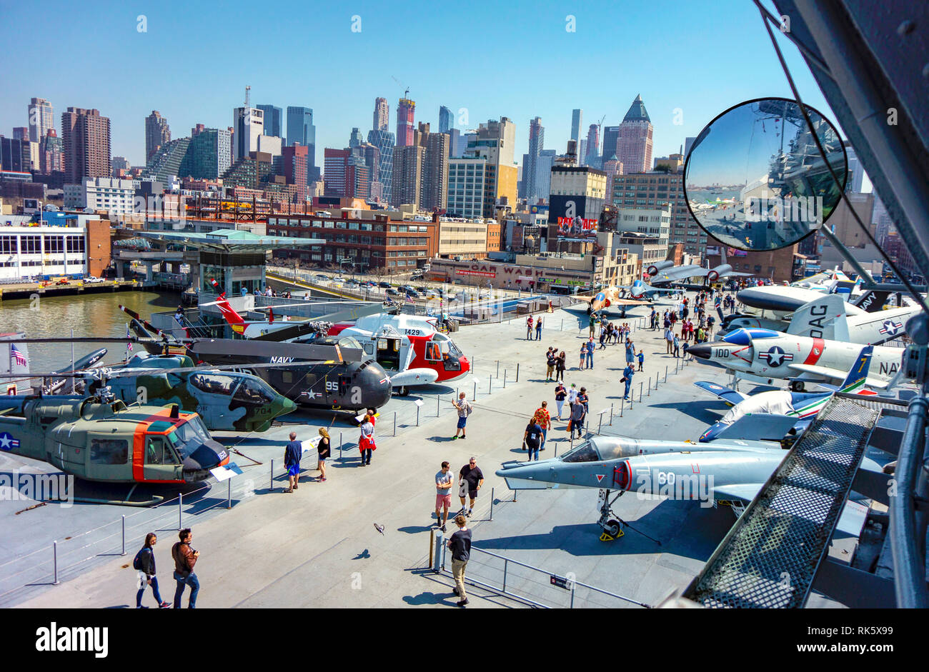 New York, NY / STATI UNITI D'AMERICA - 04.14.2018: NCY attrazione carrier Intrepid nave con il ponte di combattenti e grattacieli di Manhattan sullo sfondo Foto Stock