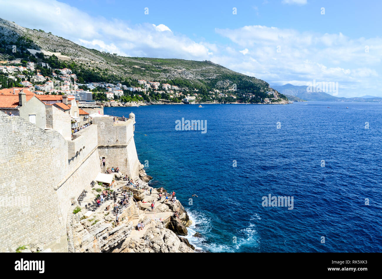 Visitatori di Dubrovnik sulle rocce del mare Adriatico Foto Stock