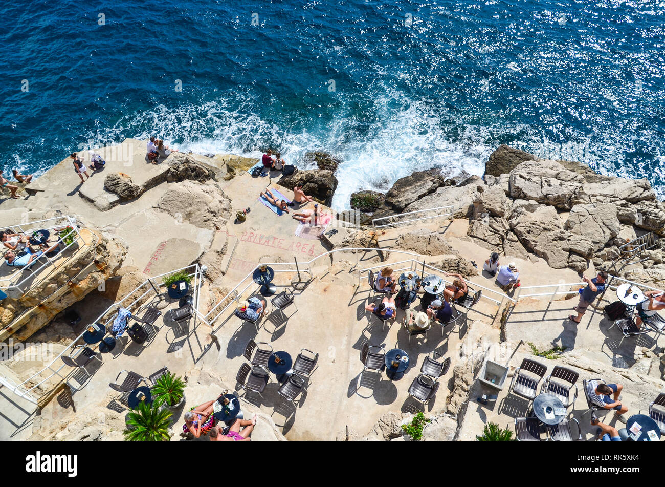 Visitatori di Dubrovnik sulle rocce del mare Adriatico Foto Stock