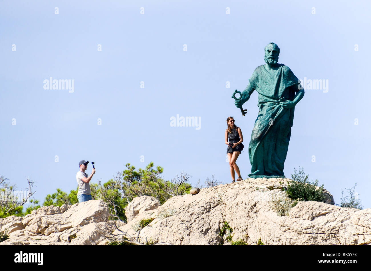 I turisti che scattano una foto vicino alla statua di San Pietro tenendo una chiave a Makarska, Croazia Foto Stock