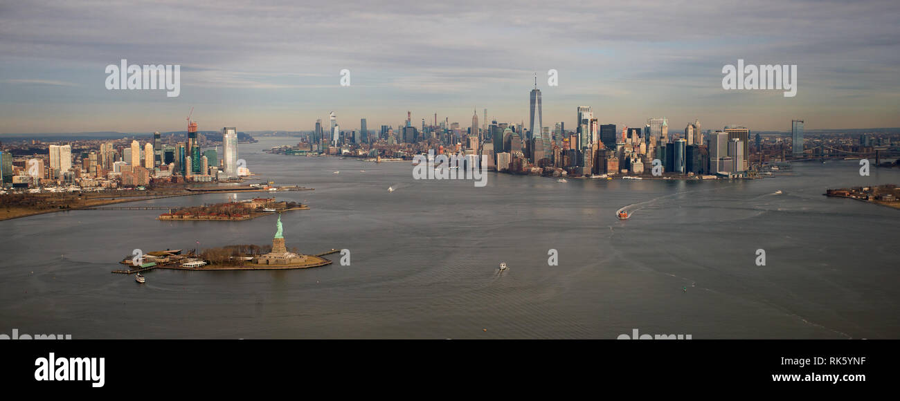 Sull'isola di Manhattan vista da un elicottero sopra il porto di New York bay guardando a nord passato Liberty Island e la statua della libertà con la città di Jersey su t Foto Stock