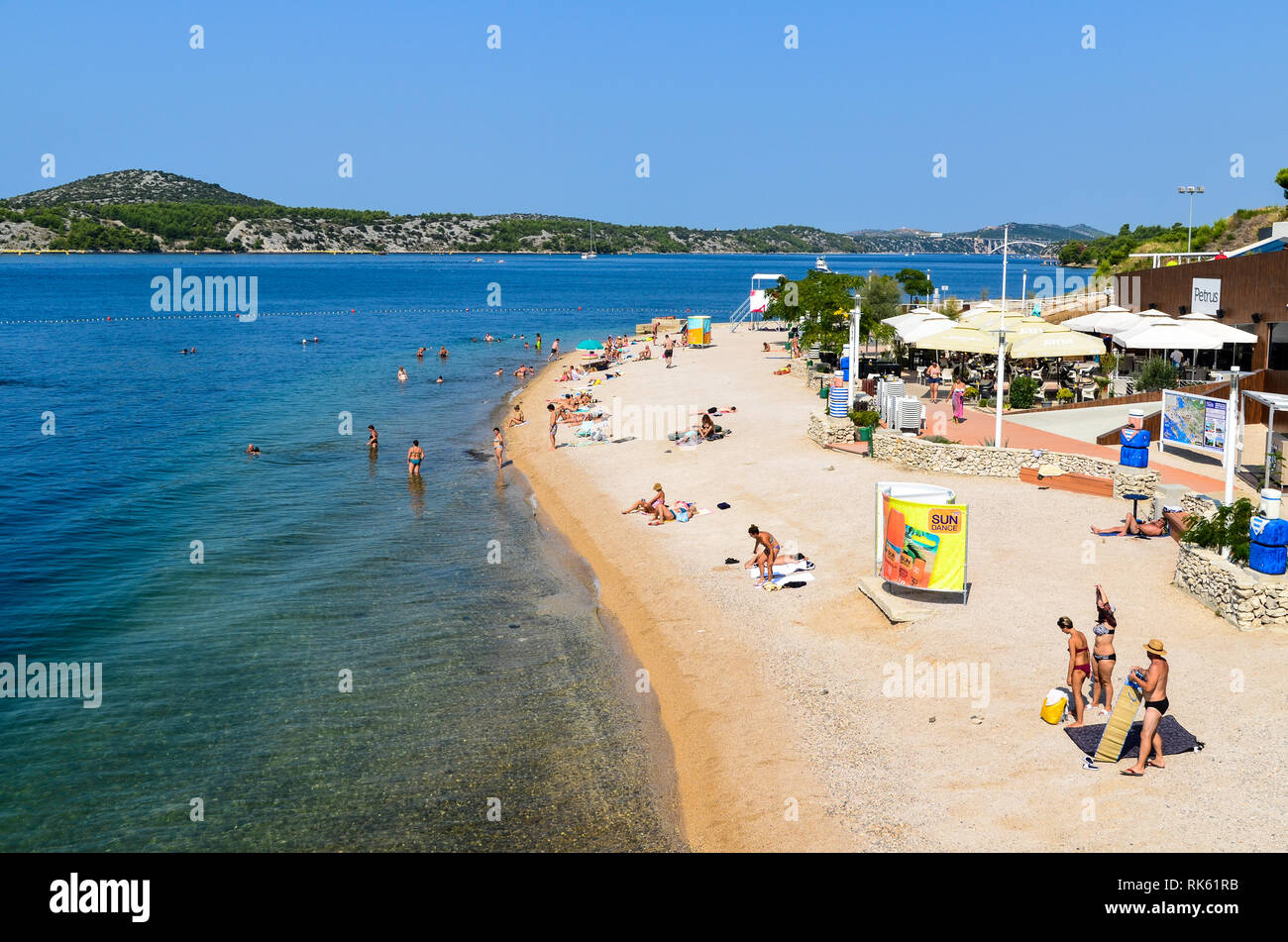 I turisti si godono una giornata di sole sulla spiaggia di Sibenik, Croazia Foto Stock