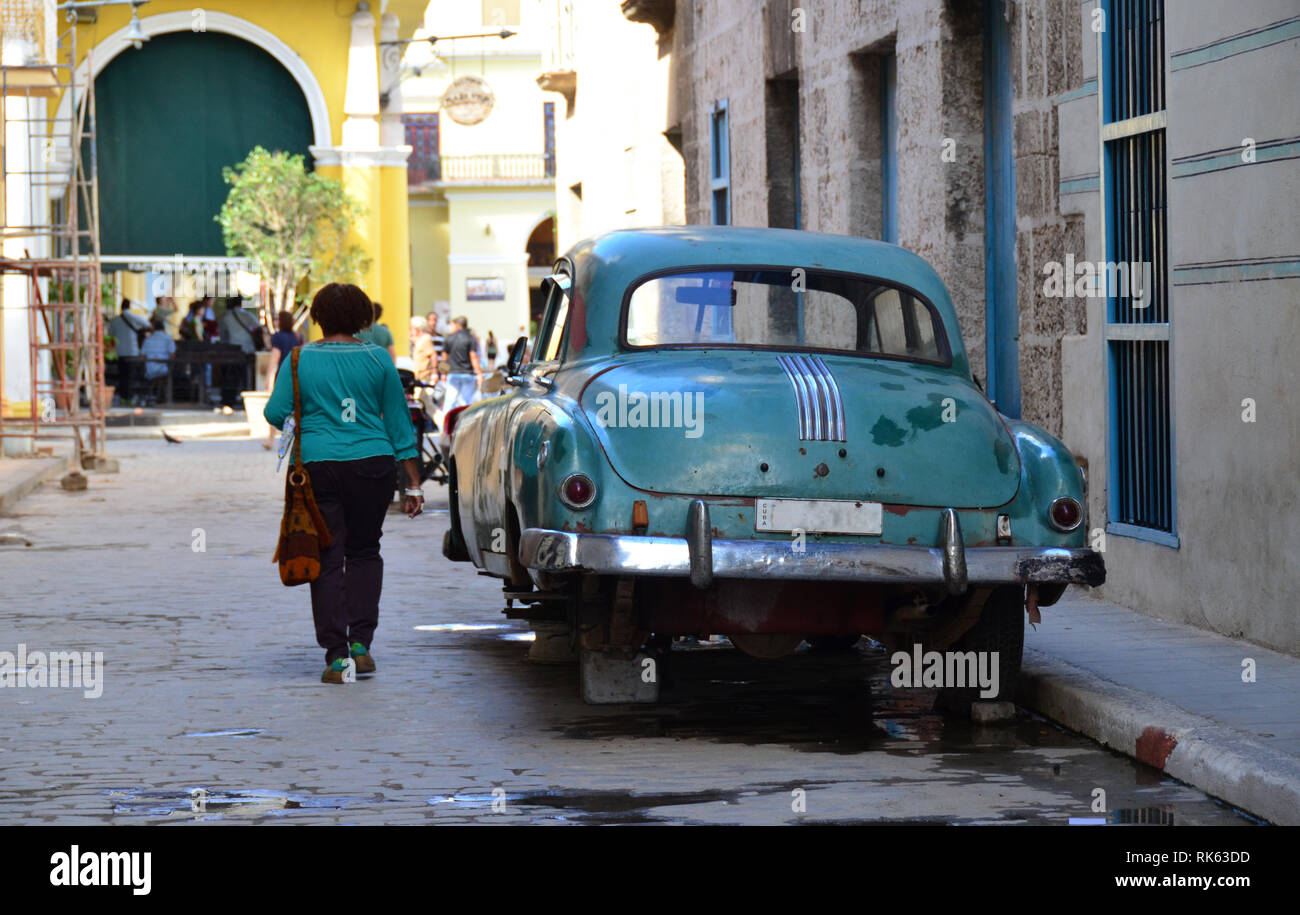 Kuba, türkis grüner Oldtimer ohne Räder, Frau im türkis grünem Oberteil Foto Stock