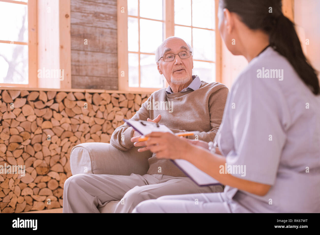 Concentrato uomo barbuto di parlare con il suo medico di base Foto Stock