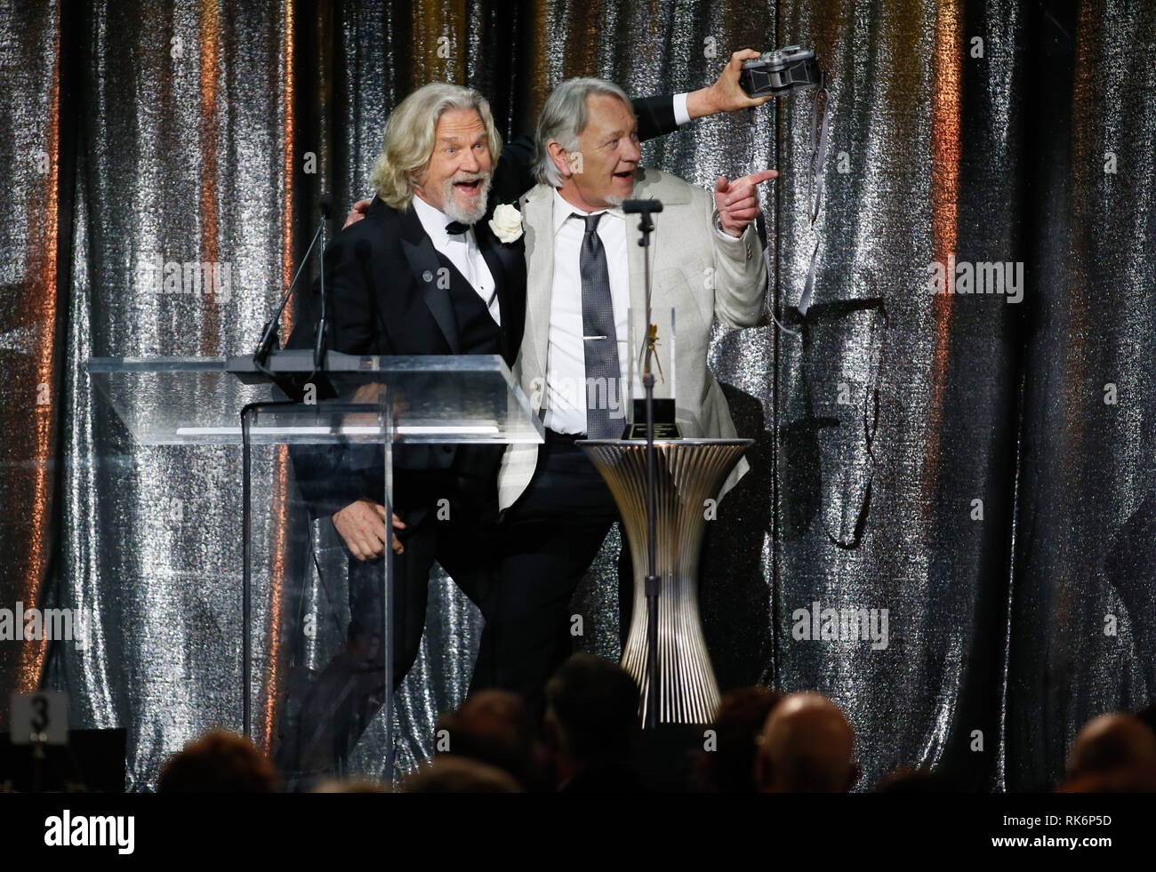 In California, Stati Uniti d'America. 9 Feb 2019. ASC consiglio dei governatori Award honoree Jeff Bridges, sinistra, utilizza una panoramica Widelux fotocamera per scattare una foto di sé e del suo stand in e controfigura presenter Loyd Catlett dopo aver accettato il suo premio in occasione della trentatreesima ASC annuale premi e la società americana di cineasti centenario celebrazione presso la Ray Dolby sala da ballo a Hollywood & Highland, Sabato, 9 febbraio 2019 a Hollywood, in California. Foto di Danny Moloshok/Moloshok fotografia, Inc./imageSPACE Credito: Imagespace/Alamy Live News Foto Stock
