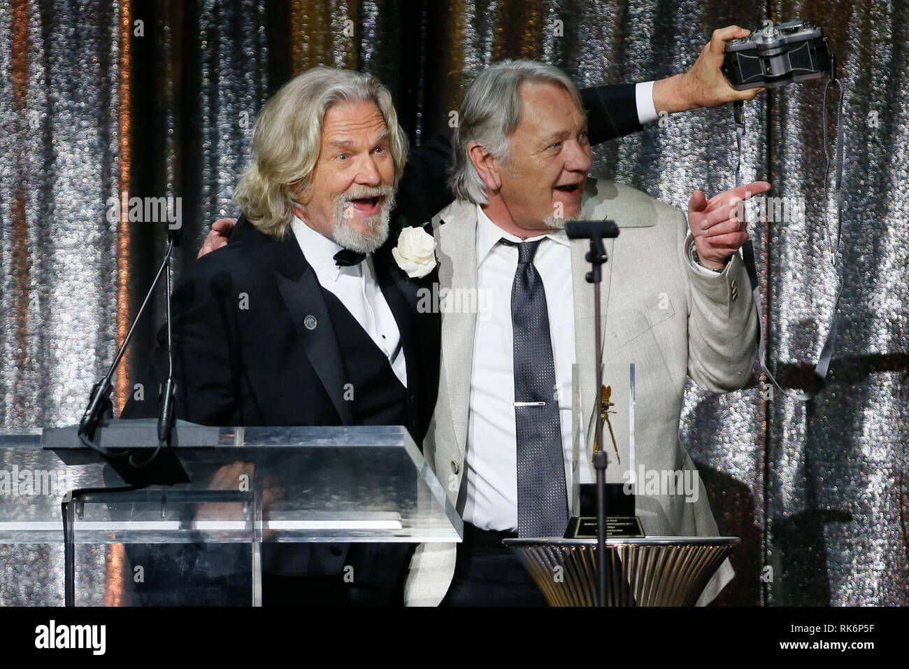 In California, Stati Uniti d'America. 9 Feb 2019. ASC consiglio dei governatori Award honoree Jeff Bridges, sinistra, utilizza una panoramica Widelux fotocamera per scattare una foto di sé e del suo stand in e controfigura presenter Loyd Catlett dopo aver accettato il suo premio in occasione della trentatreesima ASC annuale premi e la società americana di cineasti centenario celebrazione presso la Ray Dolby sala da ballo a Hollywood & Highland, Sabato, 9 febbraio 2019 a Hollywood, in California. Foto di Danny Moloshok/Moloshok fotografia, Inc./imageSPACE Credito: Imagespace/Alamy Live News Foto Stock