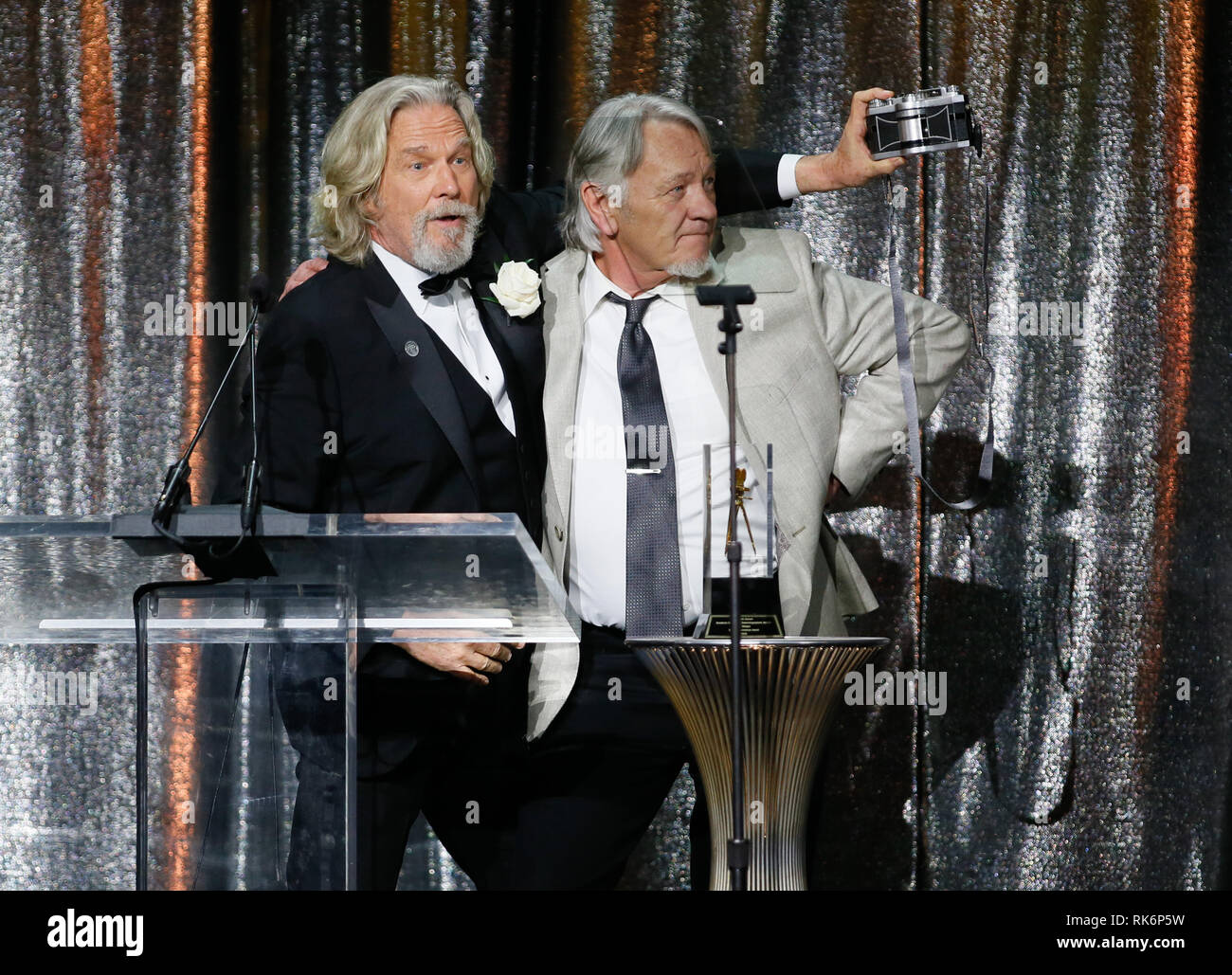 In California, Stati Uniti d'America. 9 Feb 2019. ASC consiglio dei governatori Award honoree Jeff Bridges, sinistra, utilizza una panoramica Widelux fotocamera per scattare una foto di sé e del suo stand in e controfigura presenter Loyd Catlett dopo aver accettato il suo premio in occasione della trentatreesima ASC annuale premi e la società americana di cineasti centenario celebrazione presso la Ray Dolby sala da ballo a Hollywood & Highland, Sabato, 9 febbraio 2019 a Hollywood, in California. Foto di Danny Moloshok/Moloshok fotografia, Inc./imageSPACE Credito: Imagespace/Alamy Live News Foto Stock