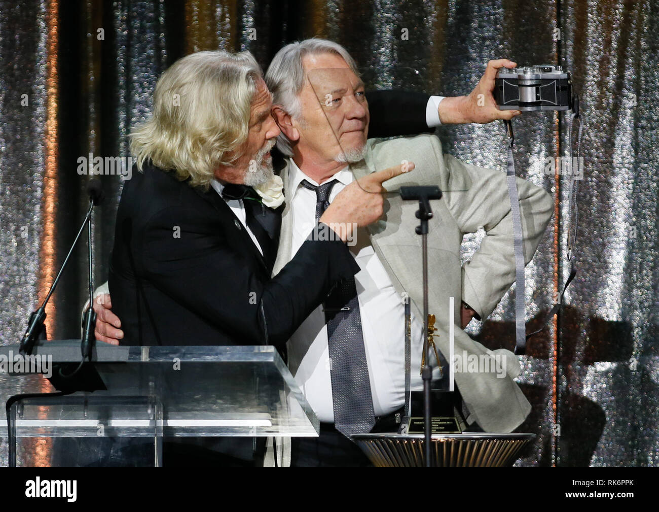 In California, Stati Uniti d'America. 10 feb 2019. In California, Stati Uniti d'America. 10 feb 2019. ASC consiglio dei governatori Award honoree Jeff Bridges, sinistra, utilizza una panoramica Widelux fotocamera per scattare una foto di sé e del suo stand in e controfigura presenter Loyd Catlett dopo aver accettato il suo premio in occasione della trentatreesima ASC annuale premi e la società americana di cineasti centenario celebrazione presso la Ray Dolby sala da ballo a Hollywood & Highland, Sabato, 9 febbraio 2019 a Hollywood, in California. Foto di Danny Moloshok/Moloshok fotografia, Inc./imageSPACE/MediaPunch Credito: MediaPunch Inc/Alamy Live News Credito: MediaPunch Foto Stock