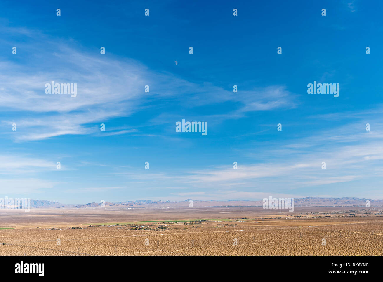 Valle del deserto bianco verde i terreni agricoli e le montagne nebuloso al di là sotto il luminoso cielo blu con nuvole bianche. Vista dalla cima della montagna alla ricerca di tutta la valle sottostante. Foto Stock