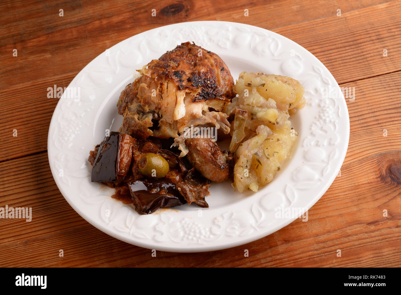 Piatto con coscia di pollo al forno con patate e caponata siciliana Foto  stock - Alamy