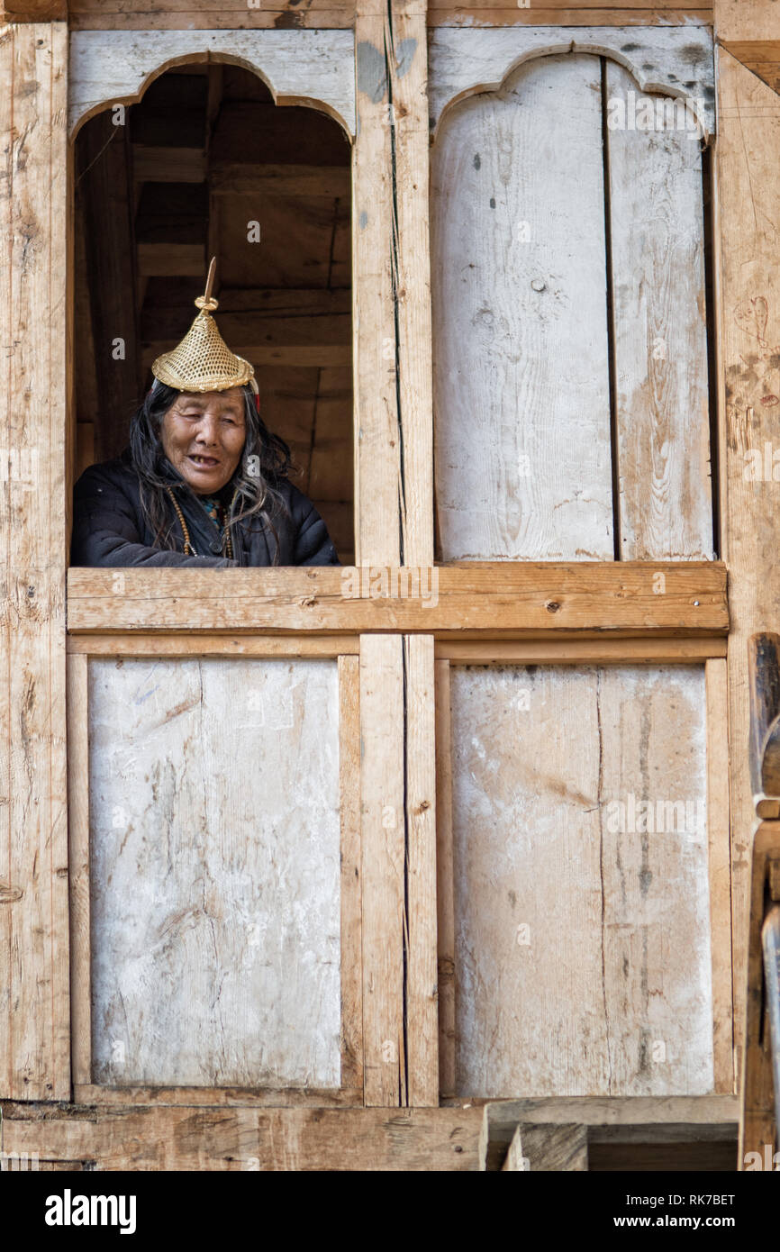 Vecchia donna Layap alla finestra della sua casa di Laya, Gasa distretto, Snowman Trek, Bhutan Foto Stock