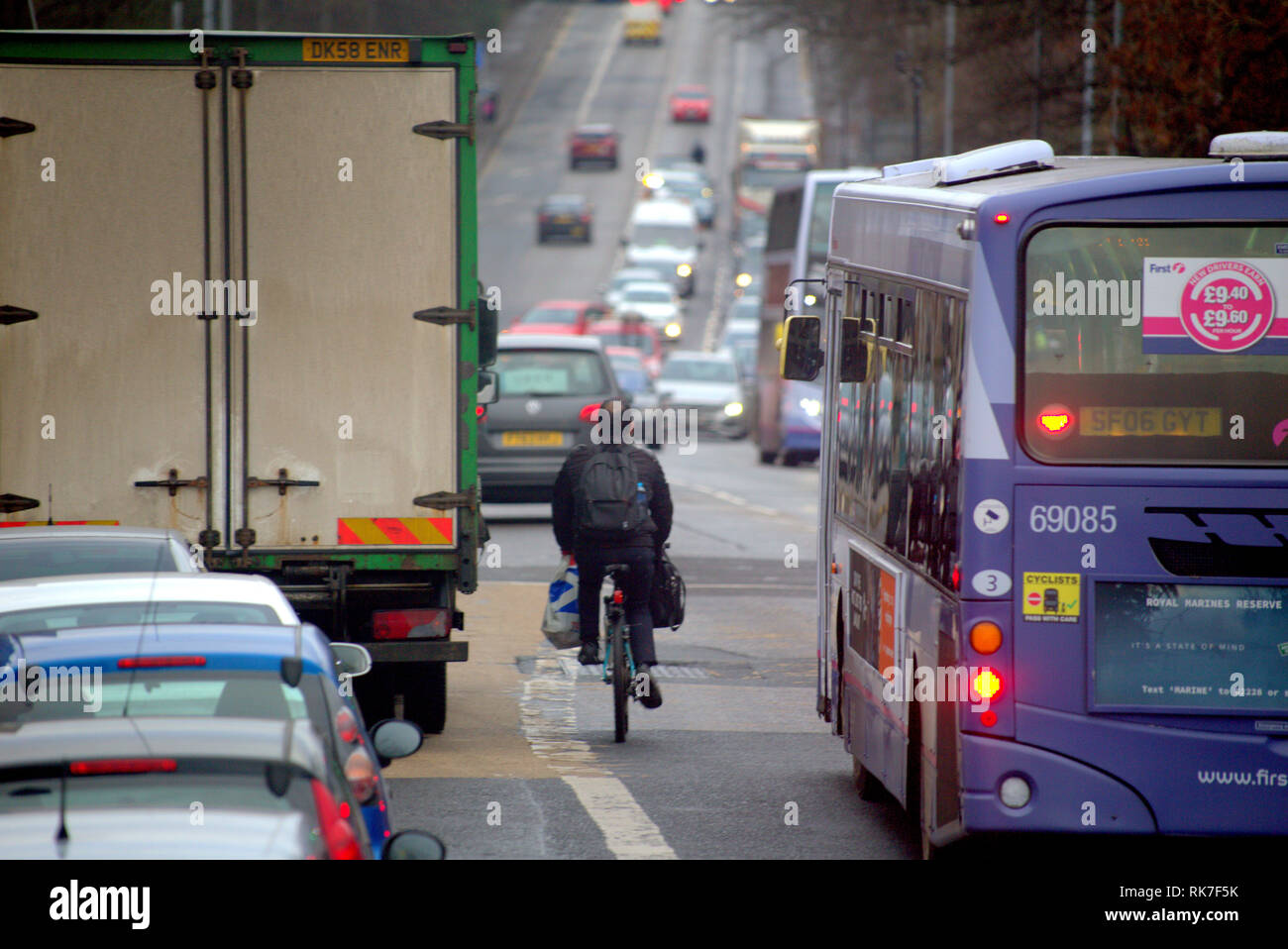 Ciclista nel traffico con le auto su una strada molto trafficata Foto Stock