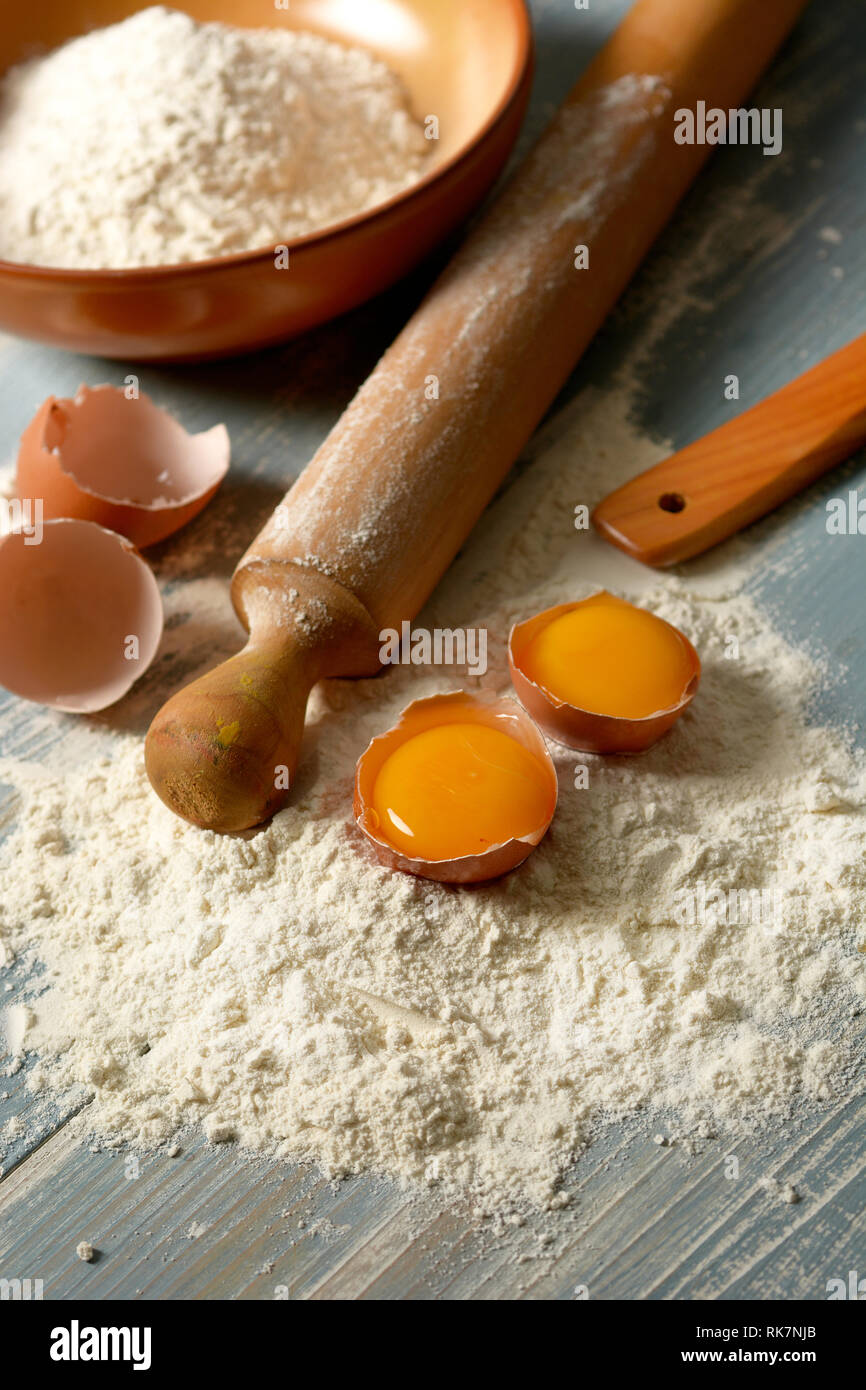 Farina di grano tenero e uova sul tavolo di legno - verticale - primo piano Foto Stock