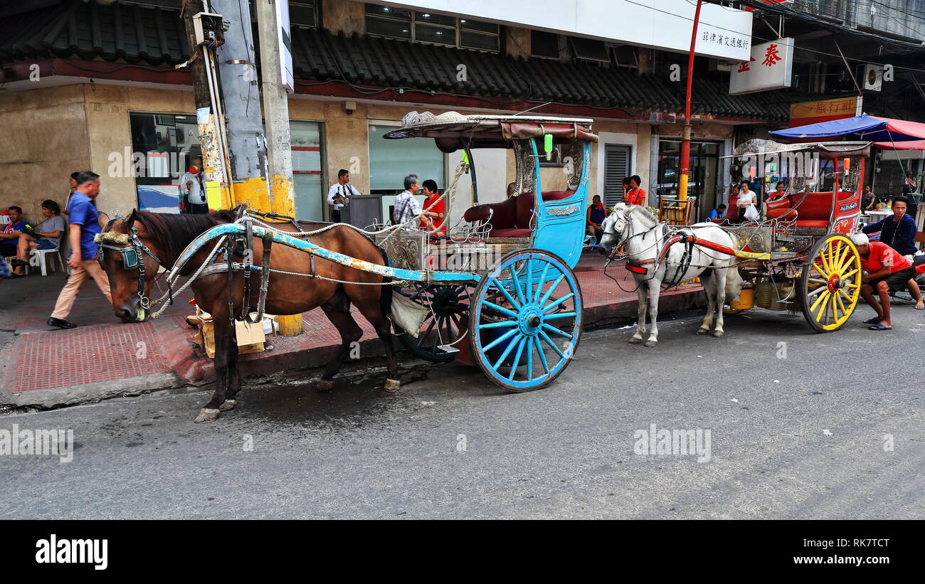 Manila, Philippines-October 24, 2016: Cavallo kalesas-calashes Smetta al Ongpin basta passare il ponte nord su San Lazaro estero in attesa Foto Stock