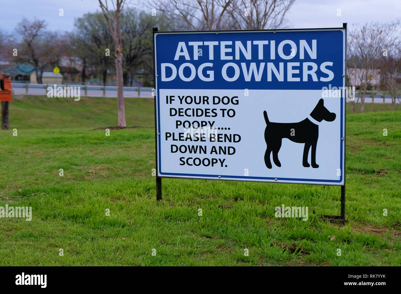 Firmare la richiesta di proprietari di cani pulizia dopo il loro pet: "Attenzione i proprietari di cani. Se il vostro cane decide di poopy si prega di piegare verso il basso e scoopy.". Foto Stock