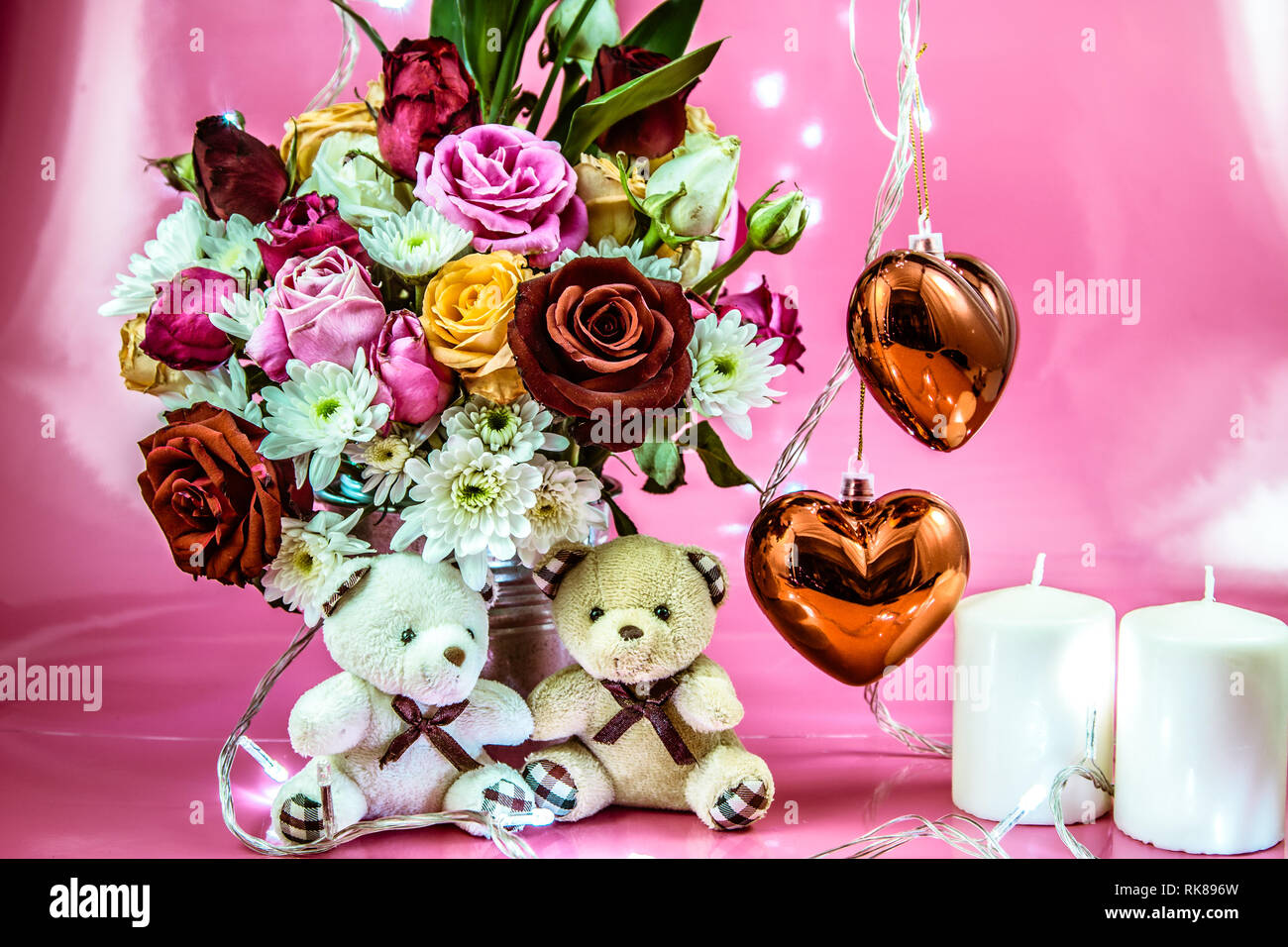 Coppia adorabile Orso sedersi vicino al vaso di bouquet di rose nel secchio in alluminio e rosso scintillante di cuore con il candelabro bianco su sfondo rosa. Valentino da Foto Stock