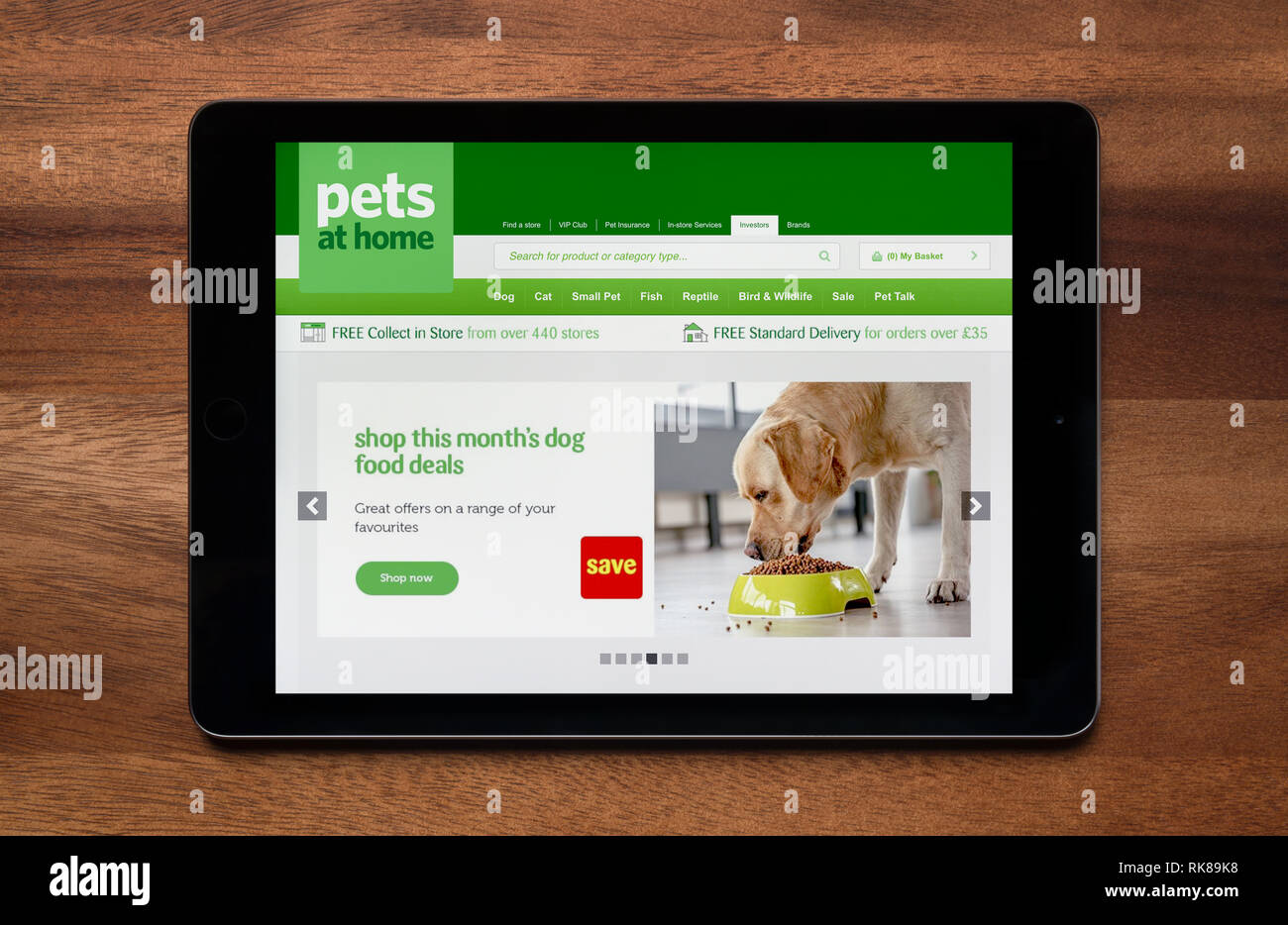 Il sito web di animali domestici in casa è visto su un tablet iPad, il quale è appoggiato su un tavolo di legno (solo uso editoriale). Foto Stock
