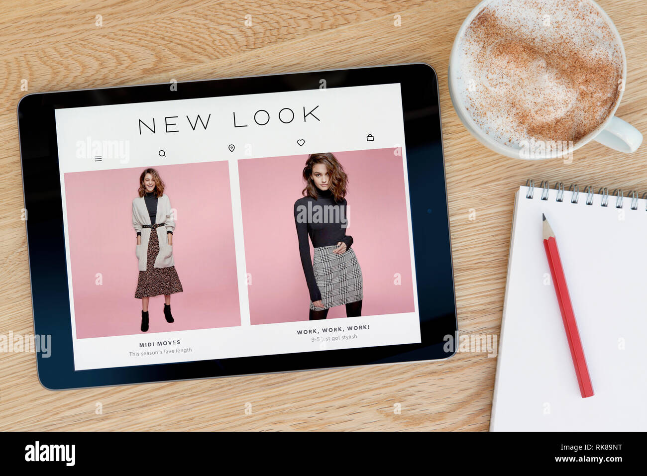 Il nuovo look funzionalità del sito su un iPad dispositivo tablet pc che si appoggia su una tavola di legno accanto a un blocco note (solo uso editoriale). Foto Stock