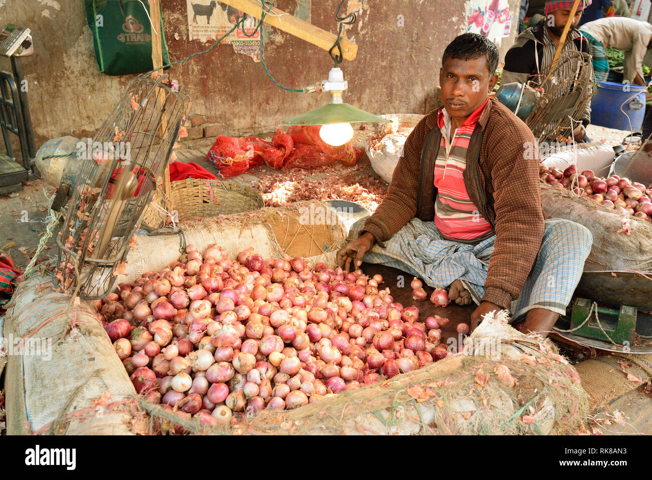 Dacca, Bengala IL BANGLADESH - 26 gennaio 2019: uomo sbucciare la cipolla sul mercato ortofrutticolo nella città capitale del Bangladesh a Dhaka Foto Stock