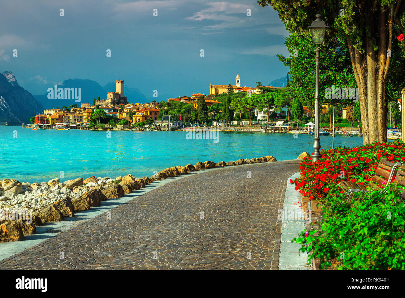 Majestic Malcesine ricreazione turistico balneare, tratto lastricato con fiori colorati e gli edifici del mediterraneo in background, lago di Garda Veneto regi Foto Stock