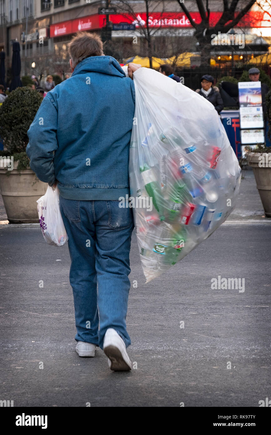 Un anonimo uomo di mezza età raccolta deposito vuoto bottiglie e lattine nei pressi di Herald Square a Manhattan, New York City. Foto Stock