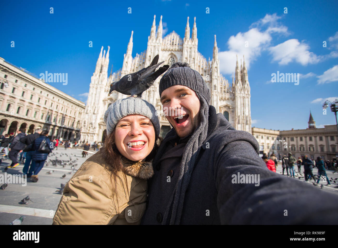 Viaggi, Italia e divertente giovane concetto - Happy turisti prendendo un autoritratto con piccioni nella parte anteriore del Duomo di Milano Foto Stock