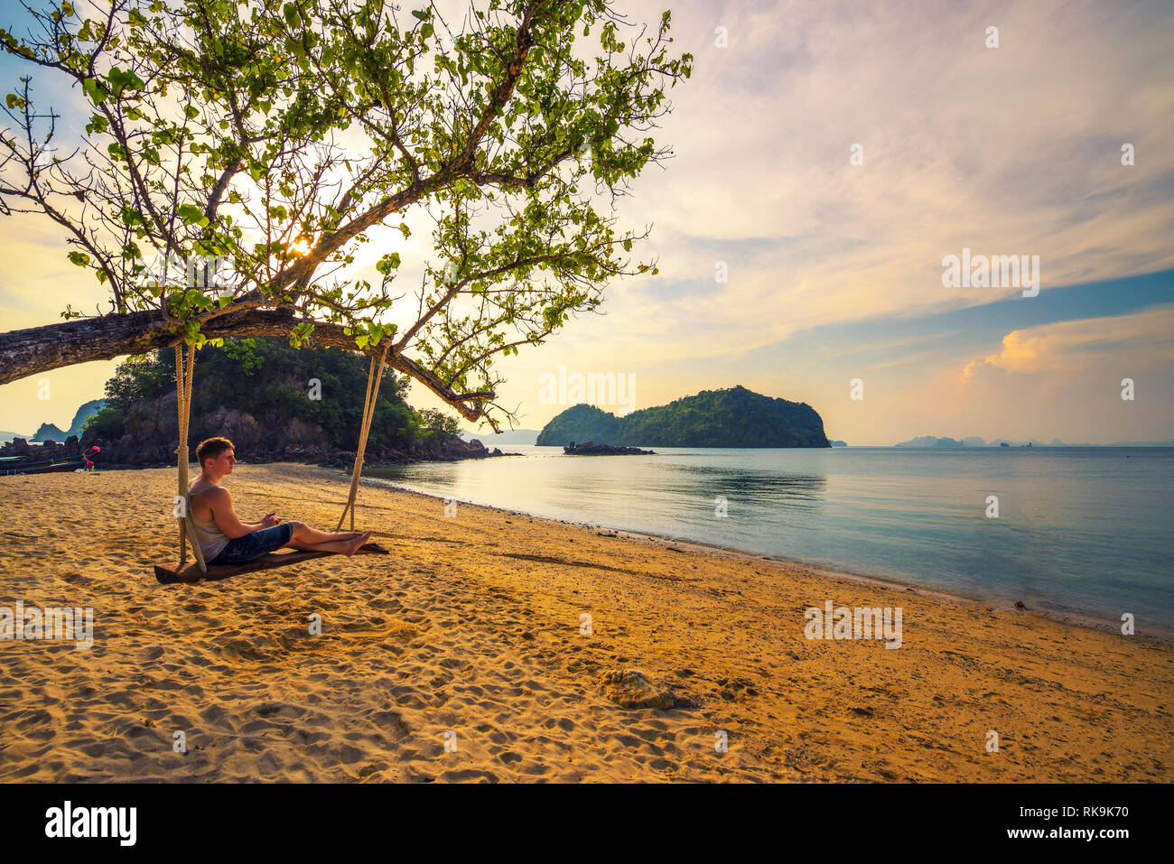 Ragazzo giovane gode di tramonto n Ko Hong Island in Thailandia Foto Stock
