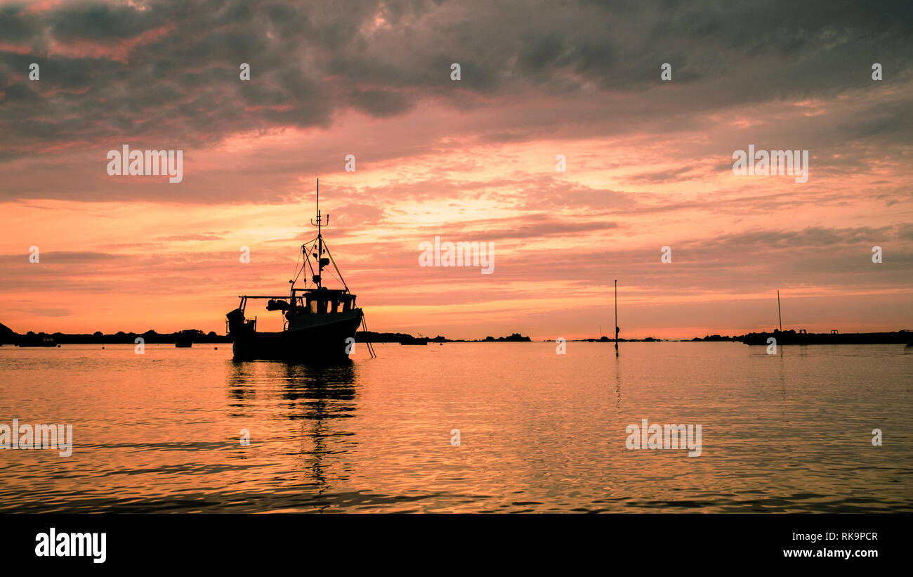 Barca da pesca contro il tramonto al Grande Harve bay Foto Stock